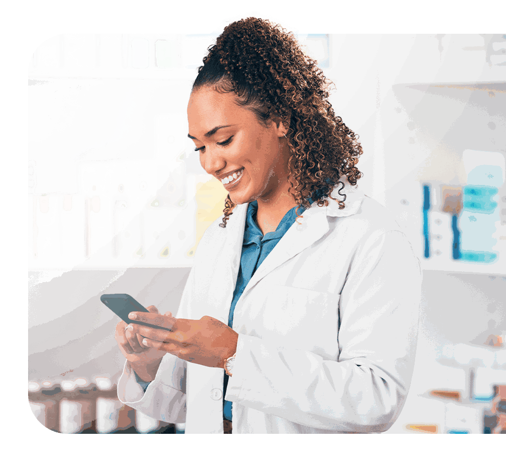 Farmacêutica sorrindo enquanto usa o celular na farmácia